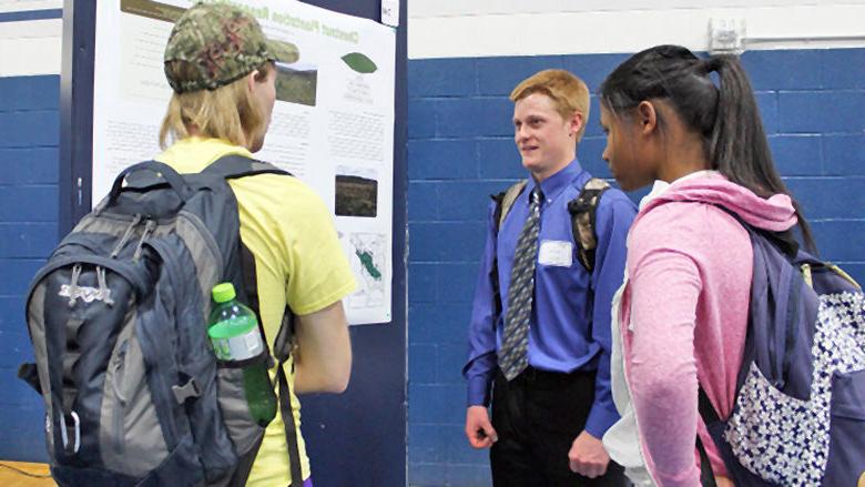 Students discuss poster display at 2016 Academic Festival