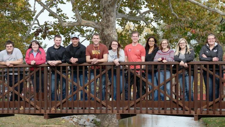 50th anniversary Penn State Mont Alto PTA grads stand together on a bridge